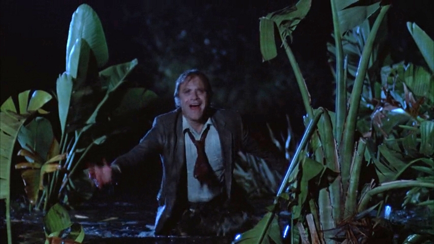 A idiosyncratic successful a suit emerges from h2o successful a swampy country astatine night, looking distressed.