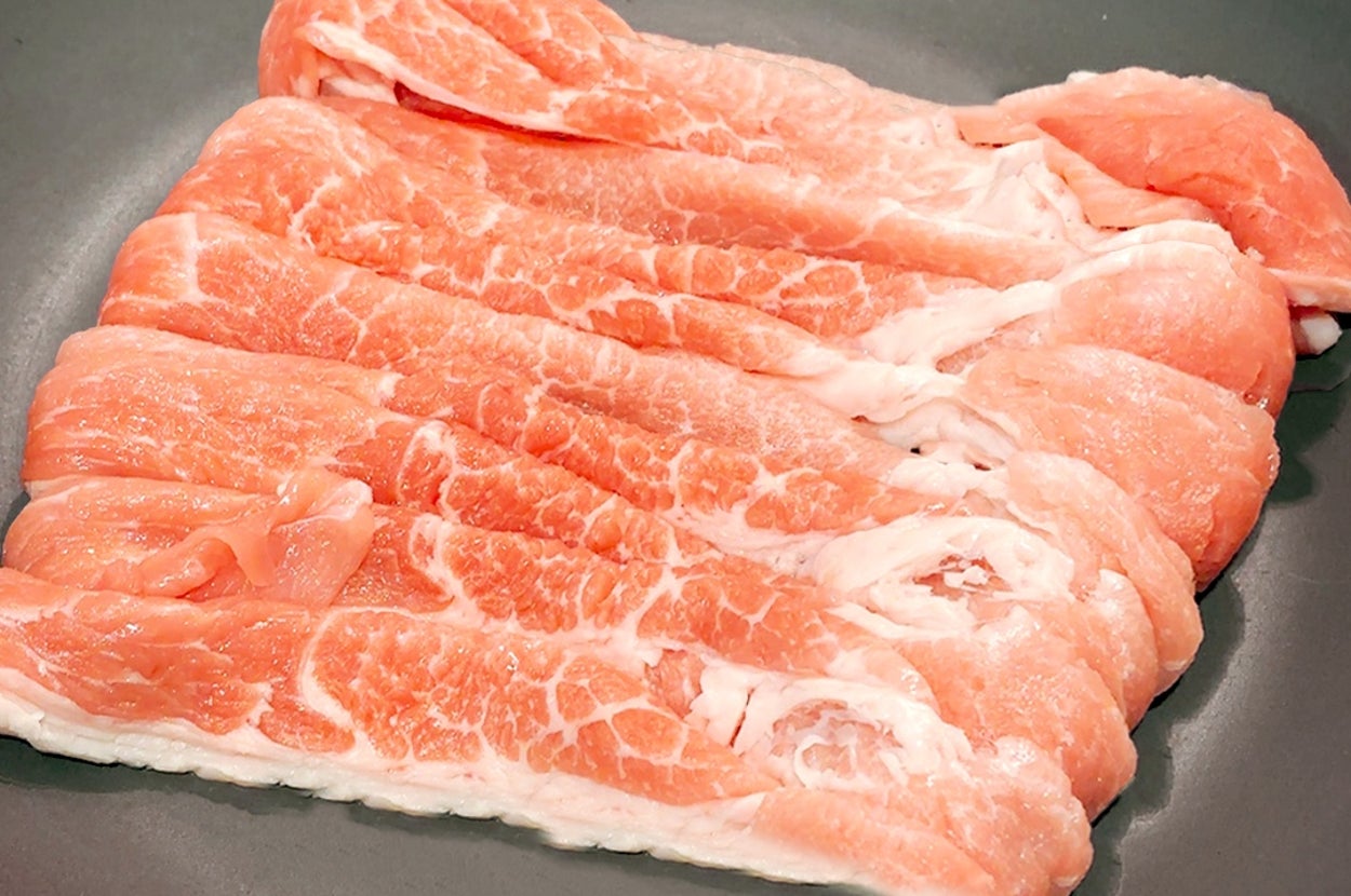 フライパンに並んだ薄切りの肉。