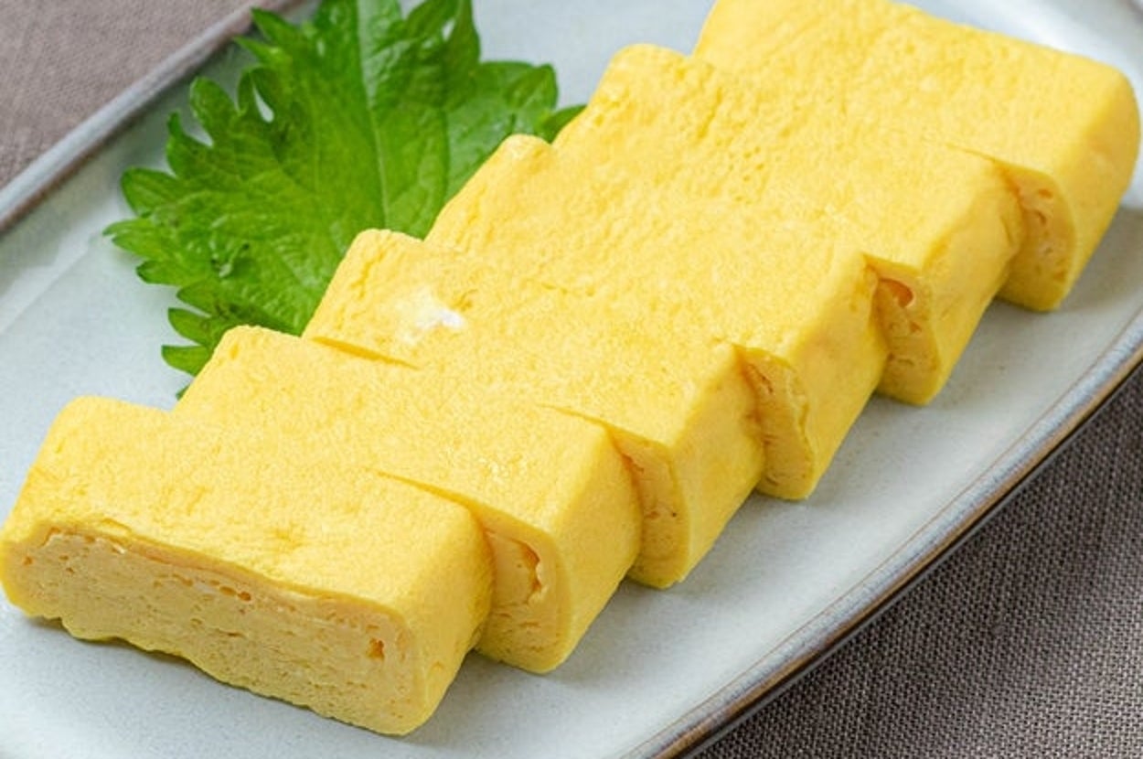 卵焼きが葉の上にきれいに並べられた料理。