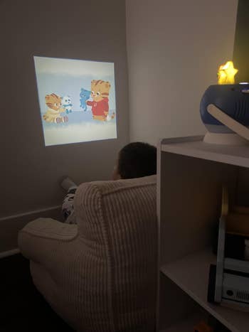 Child successful cozy seat watching animated carnal country projected connected wall