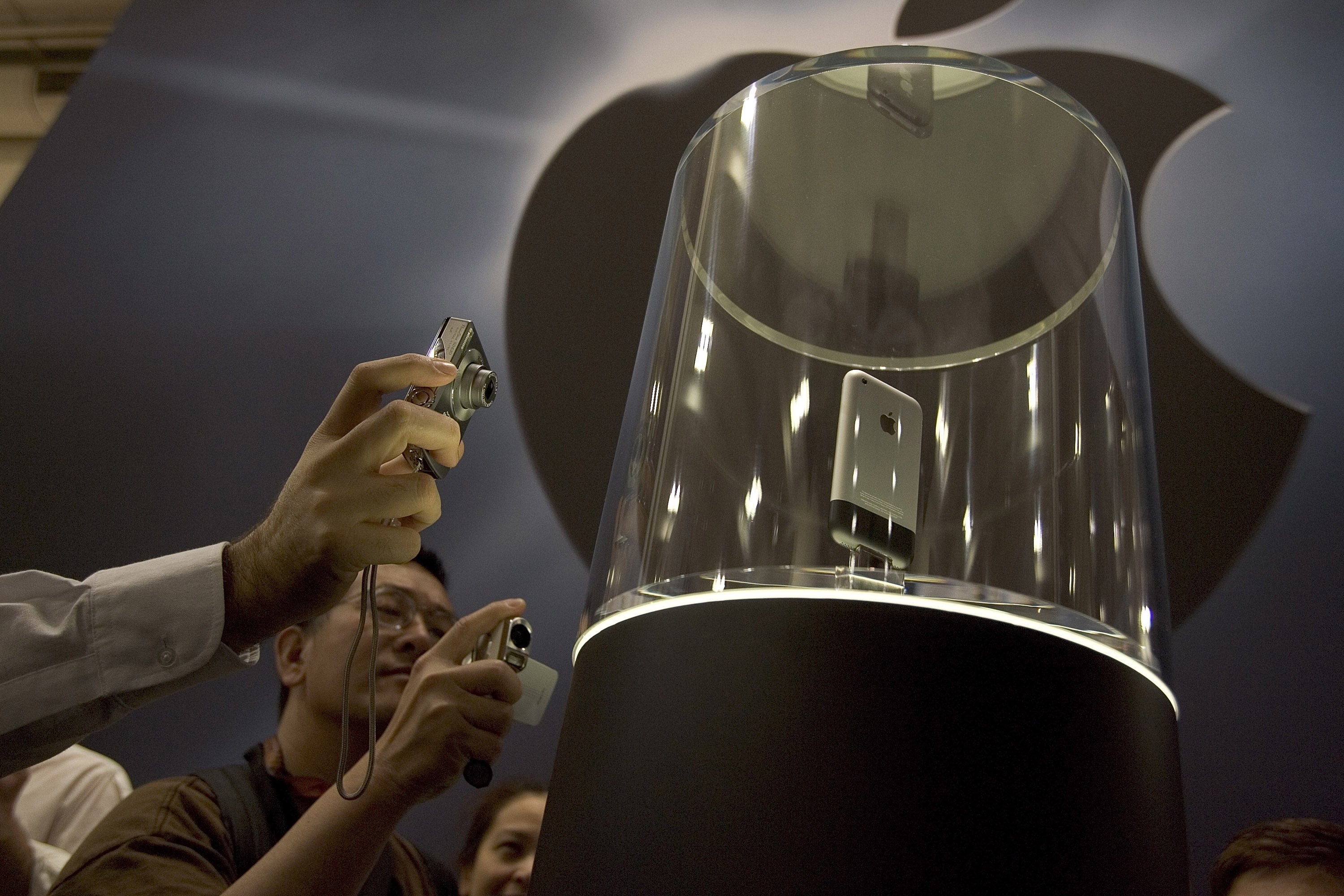 People photographing the first-generation iPhone displayed successful  a solid  lawsuit  astatine  a tech event