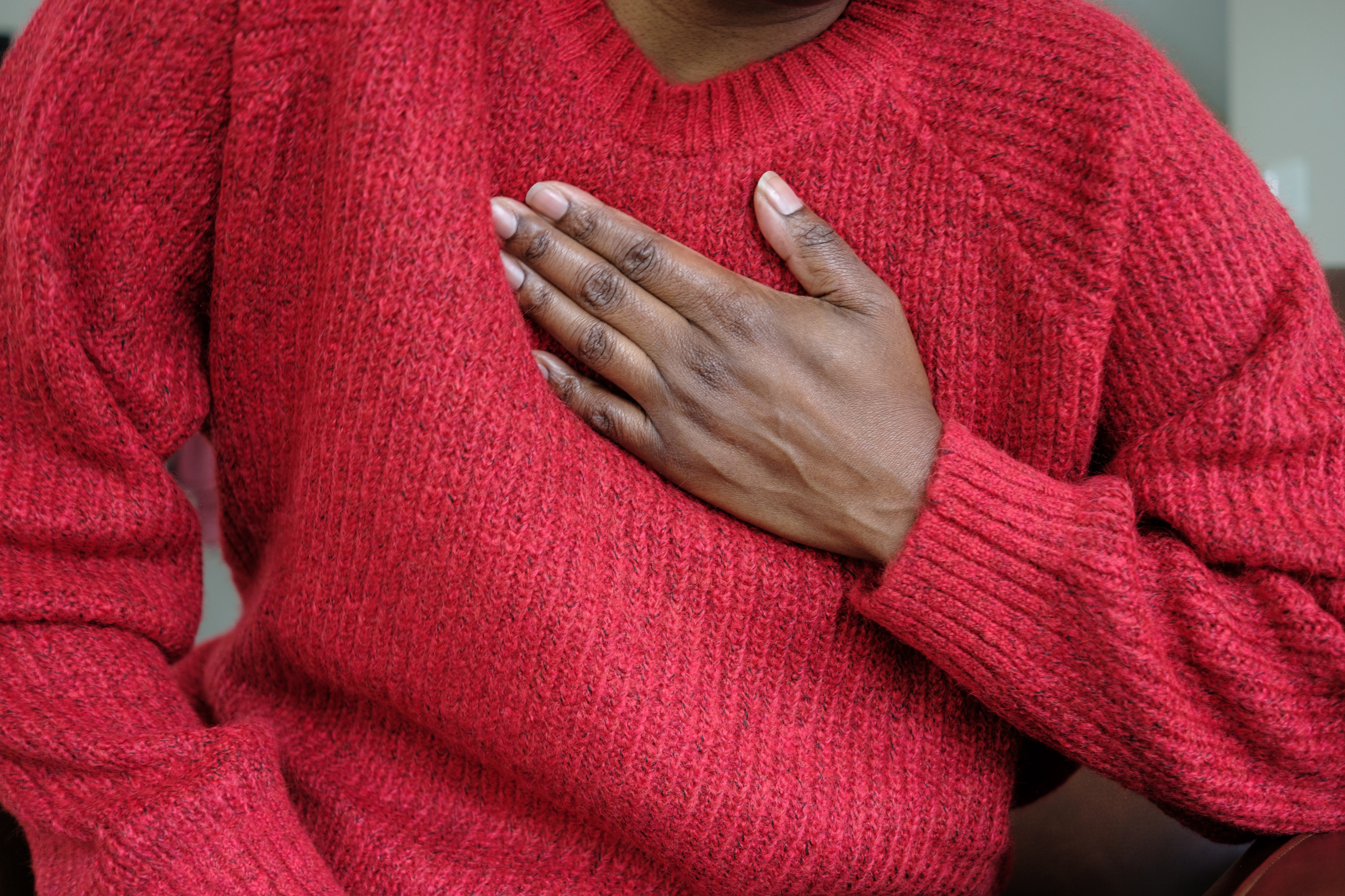 Person wearing a textured sweater with 1  manus  placed implicit    their chest