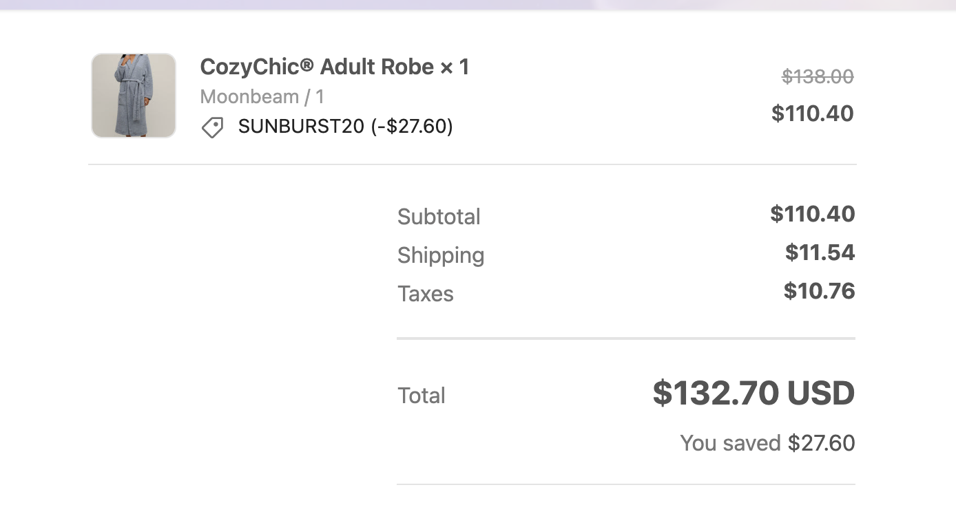Kvittering som viser en CozyChic® voksenkåpe med rabatt påført via koden SUNBURST20. Total kostnad er $132,70 USD etter $27,60 besparelser