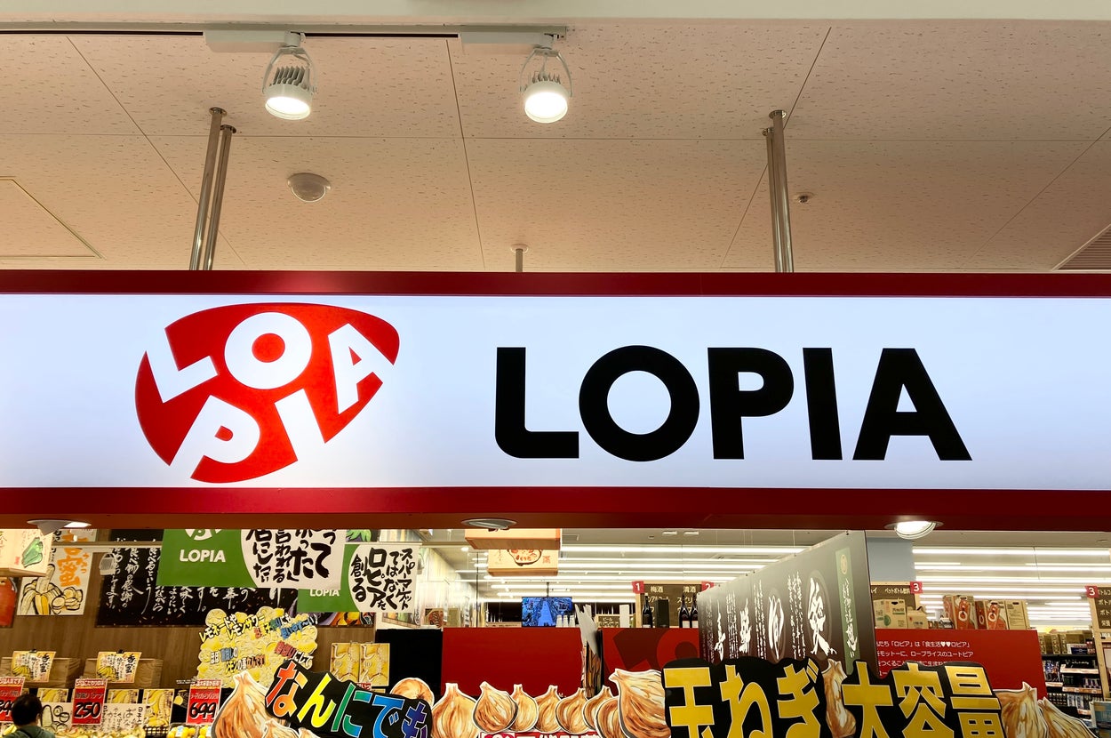 スーパーマーケット「Lopia」の看板と店舗前に商品が並ぶ様子。