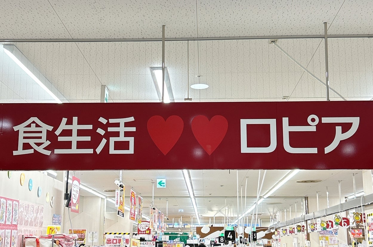 スーパーマーケットの店内看板。食生活 ❤️❤️ ロピアと書かれています。店内は買い物客で賑わっています。