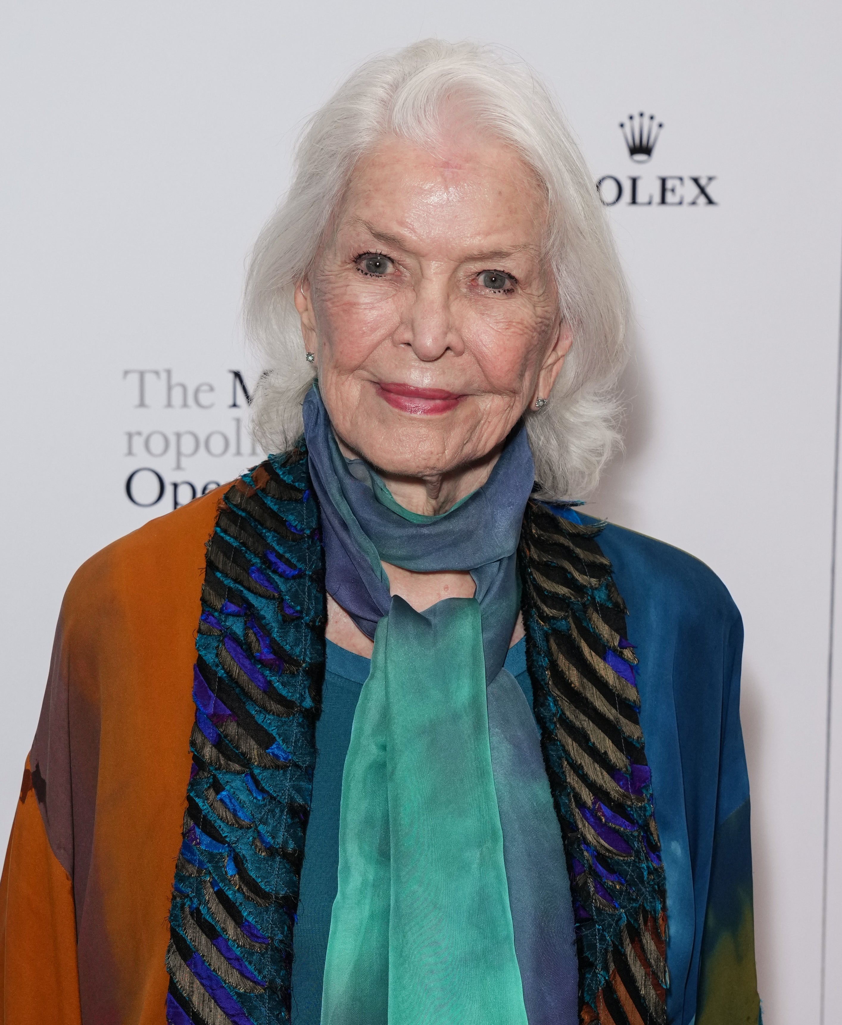 Elderly woman with white hair in elegant shawl attends event
