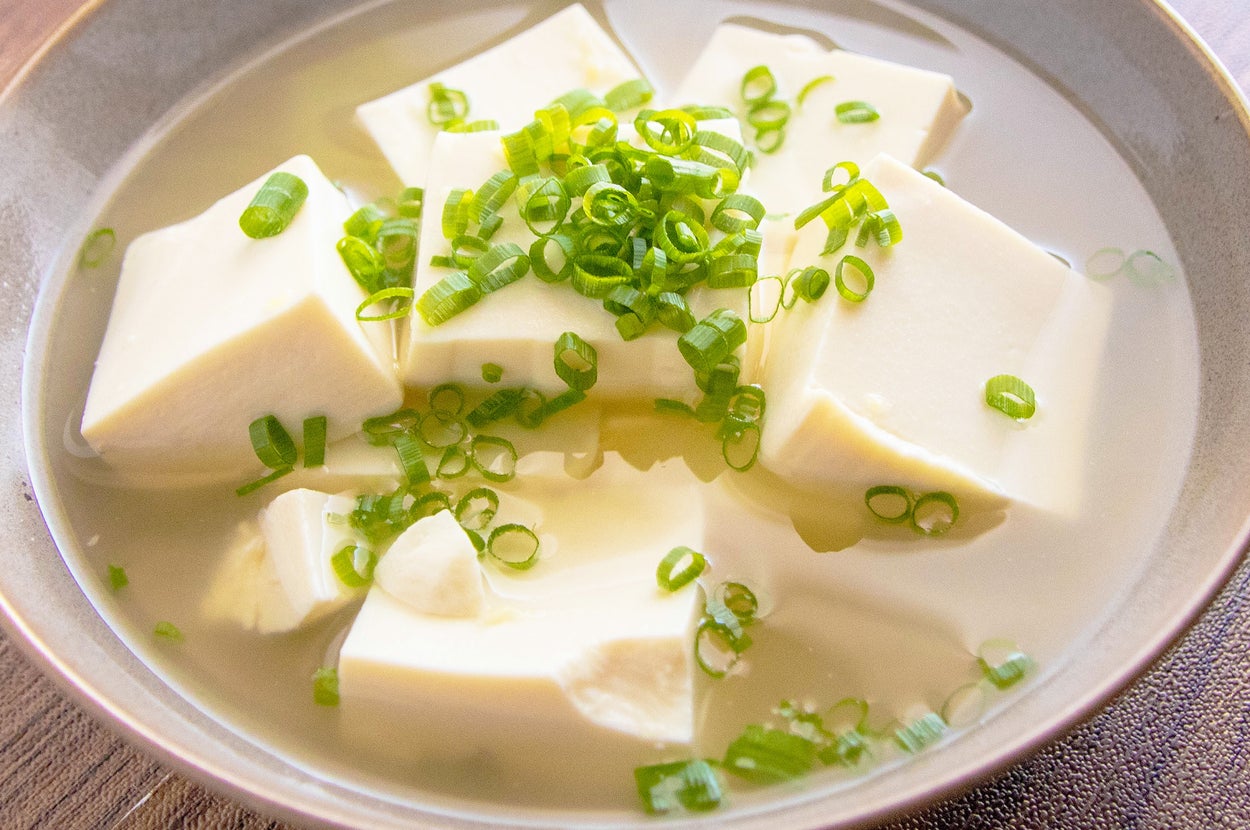 豆腐とネギが乗ったスープのボウル。