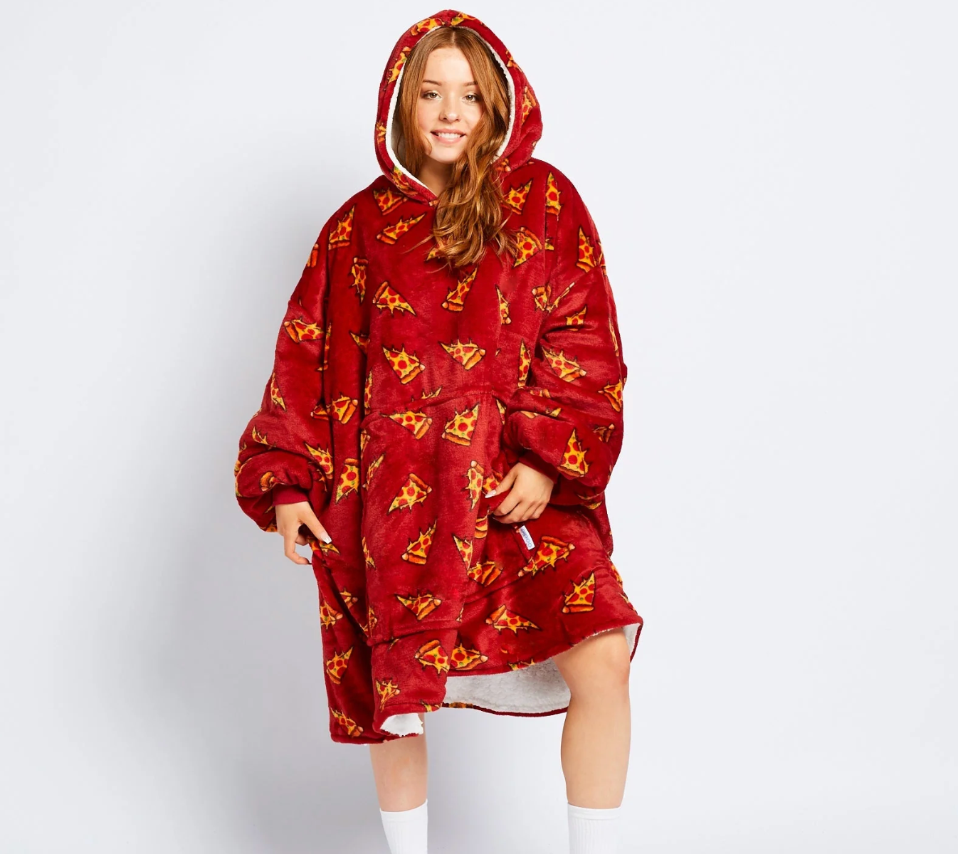 Person wearing an oversized, hooded, fleece broad with a pattern, cleanable for cozy lounging