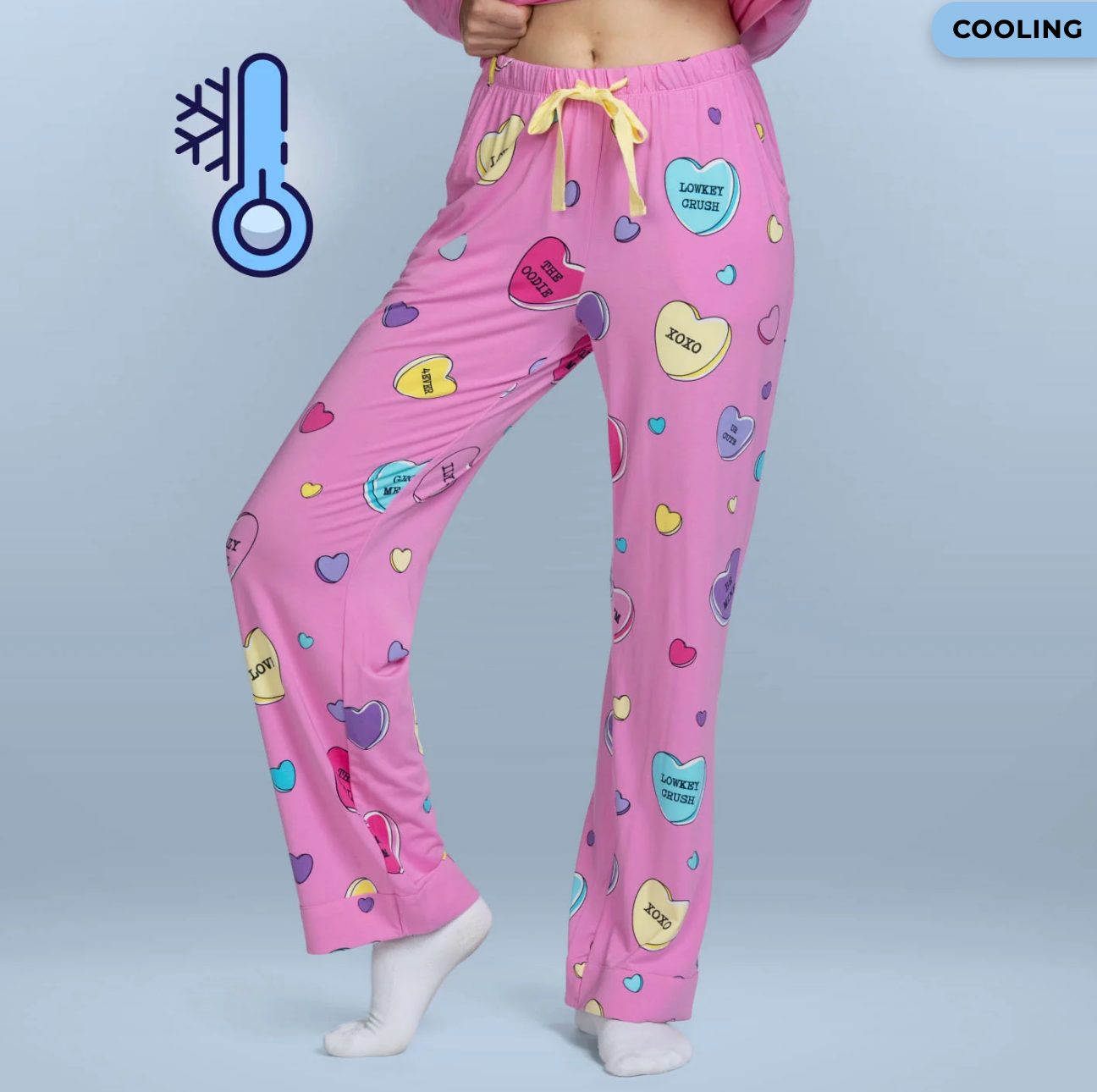 Pink pajama pants with bosom patterns and playful phrases, shown successful a buying show with a cooling icon