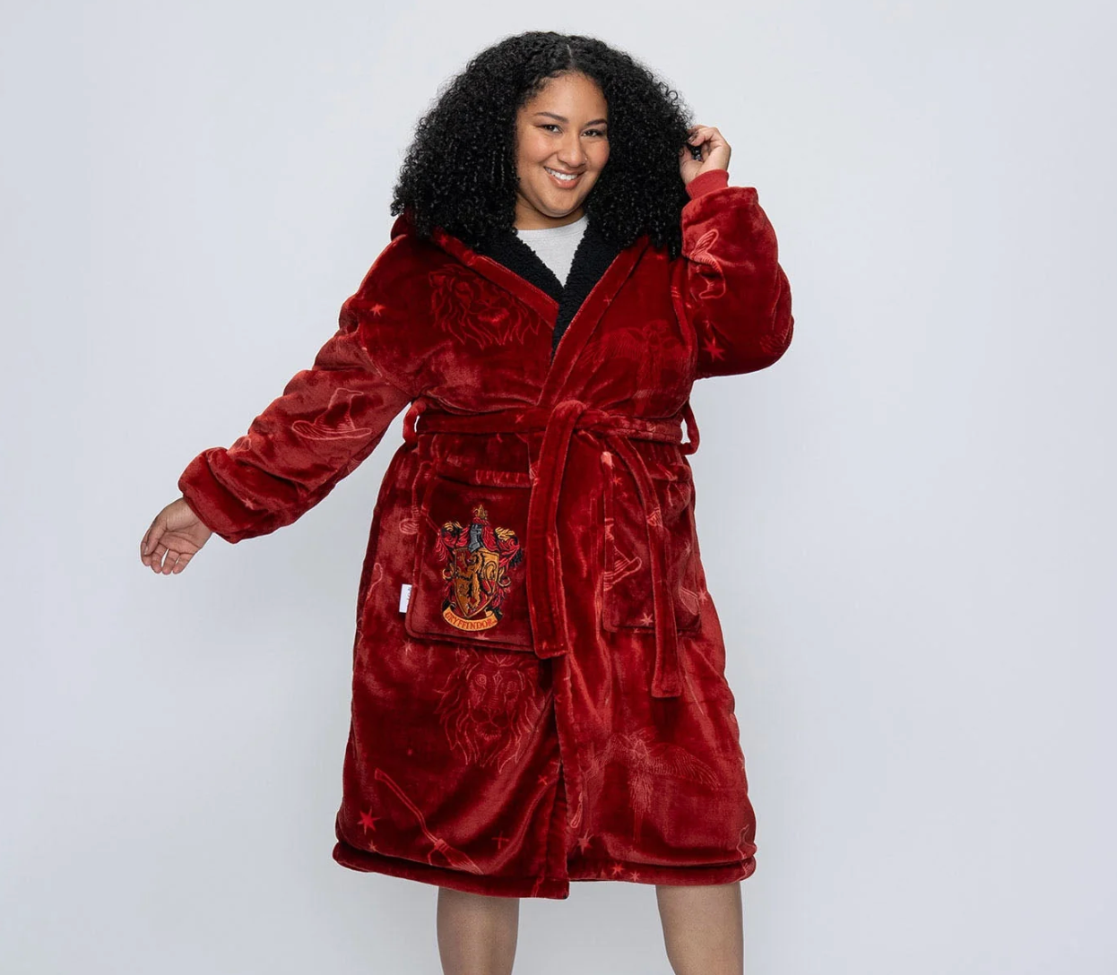 Person wearing a plush robe with a crest connected the pocket, posing confidently. Suitable for cozy, stylish lounging and relaxing astatine home