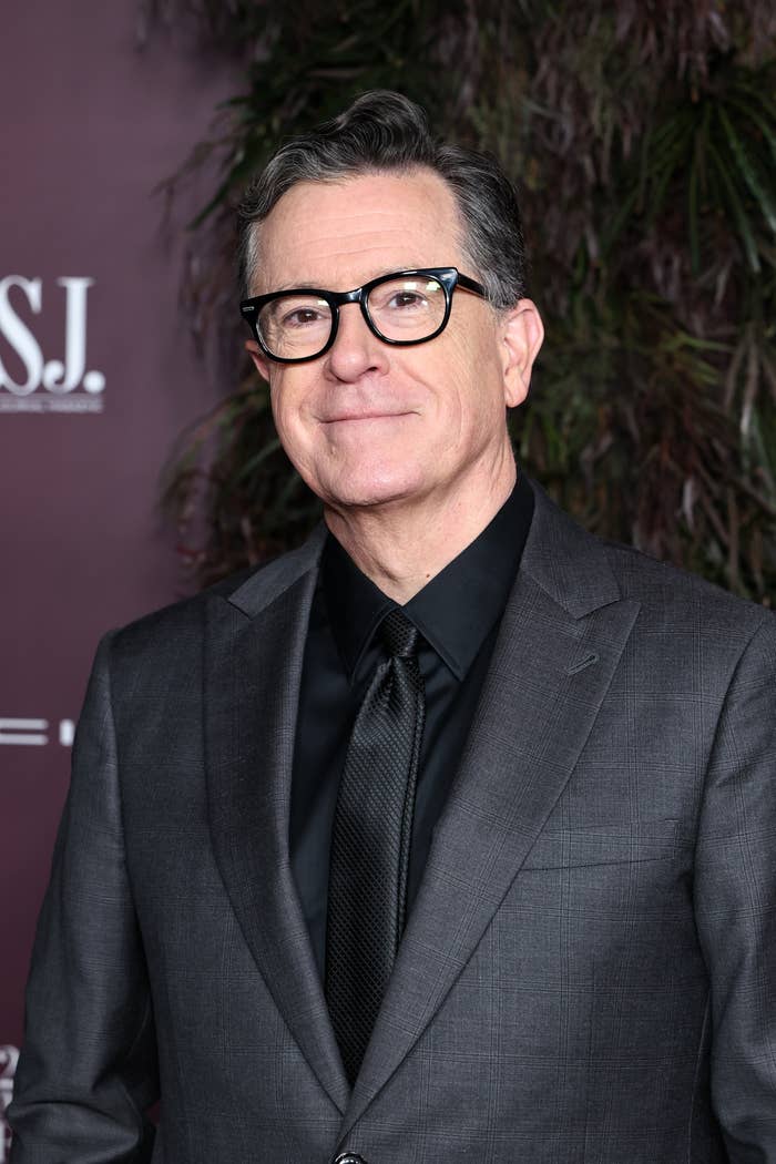 Person successful  a tailored suit   with acheronian  garment  and tie, smiling astatine  a ceremonial  event