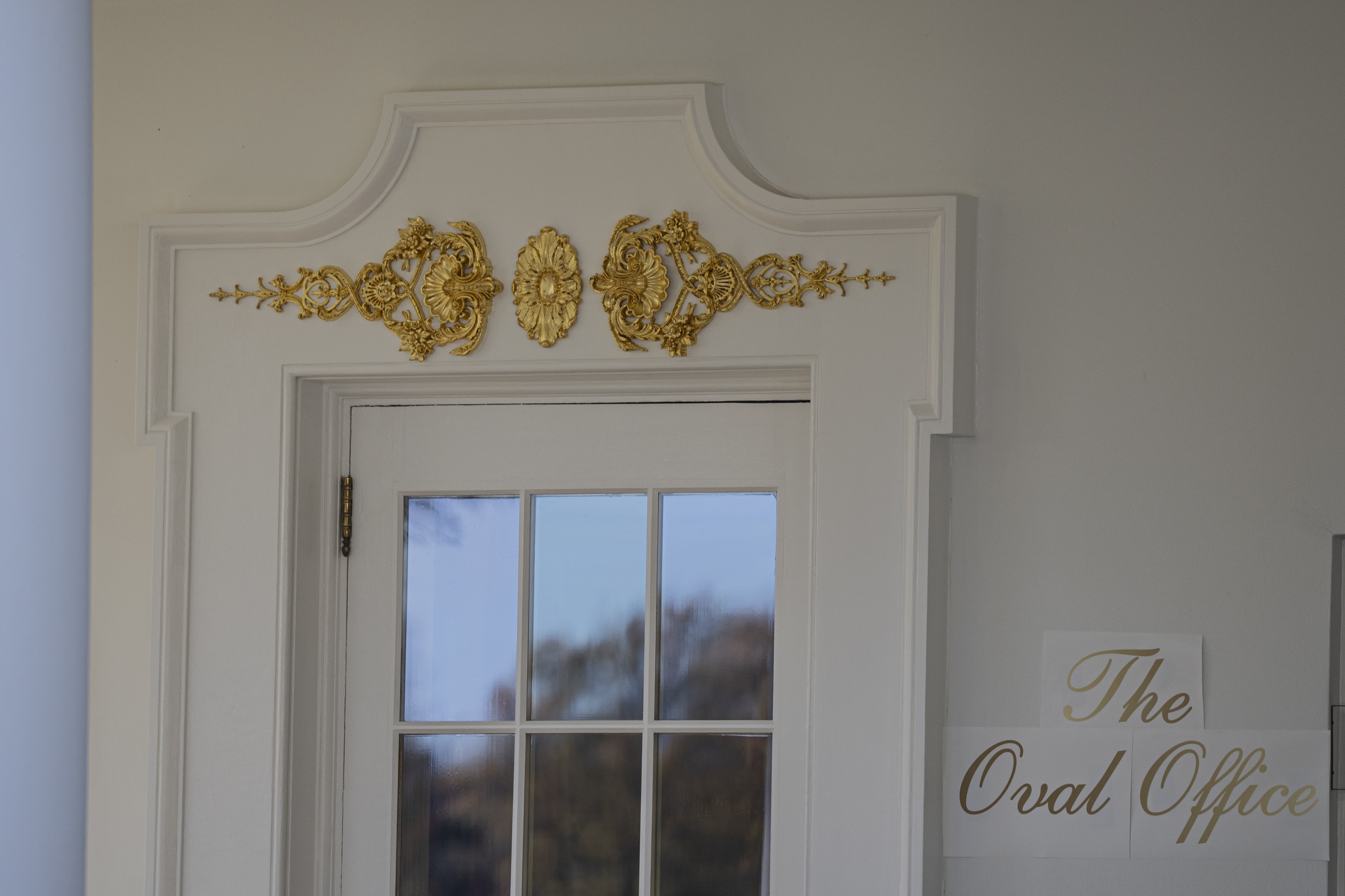 Door to the Oval Office with ornate golden  detailing supra  and a motion   to the broadside  speechmaking  &quot;The Oval Office&quot;