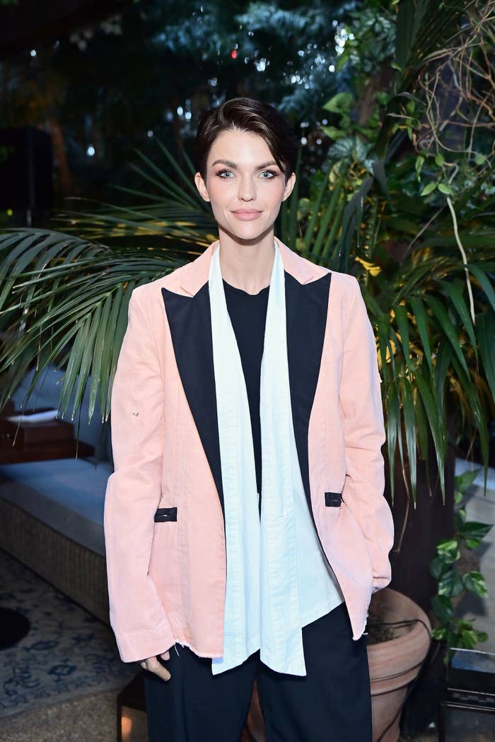 A idiosyncratic   successful  a stylish oversized blazer with wide   lapels and casual covering  underneath poses successful  beforehand   of lush greenery astatine  an event