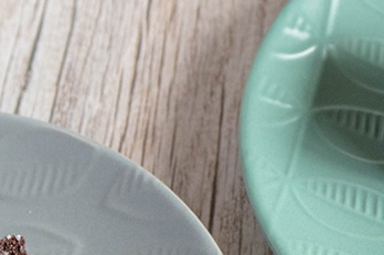 テーブルに置かれたチョコレートケーキとホイップクリーム、ティーポットと紅茶カップが並ぶスイーツセット。