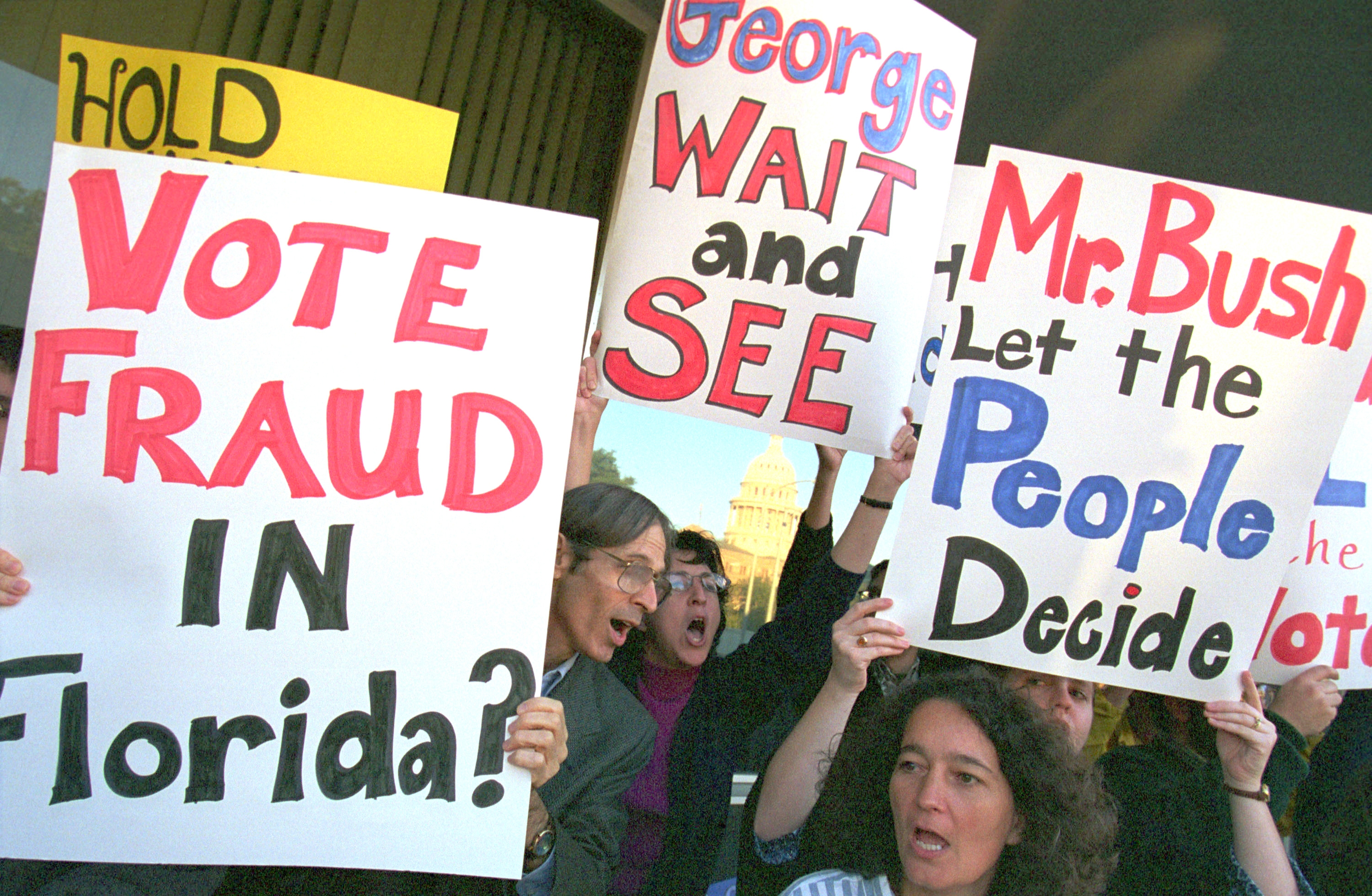 Protesters clasp  signs questioning ballot  fraud successful  Florida and urging determination  by the people