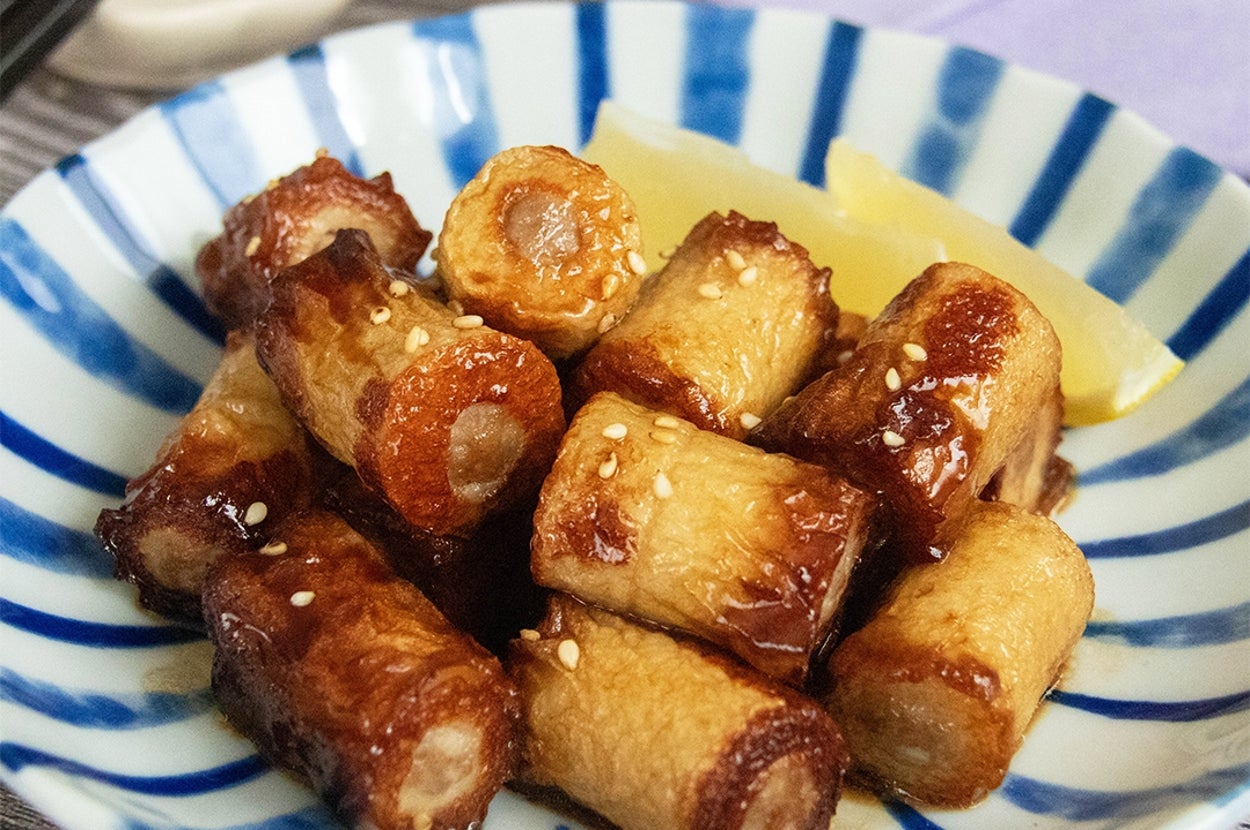 皿に盛られたちくわの肉詰め焼き。白いりごまが振られている。