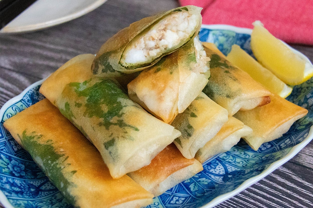 皿に盛られたツナとはんぺんの春巻きがレモンと共に置かれています。