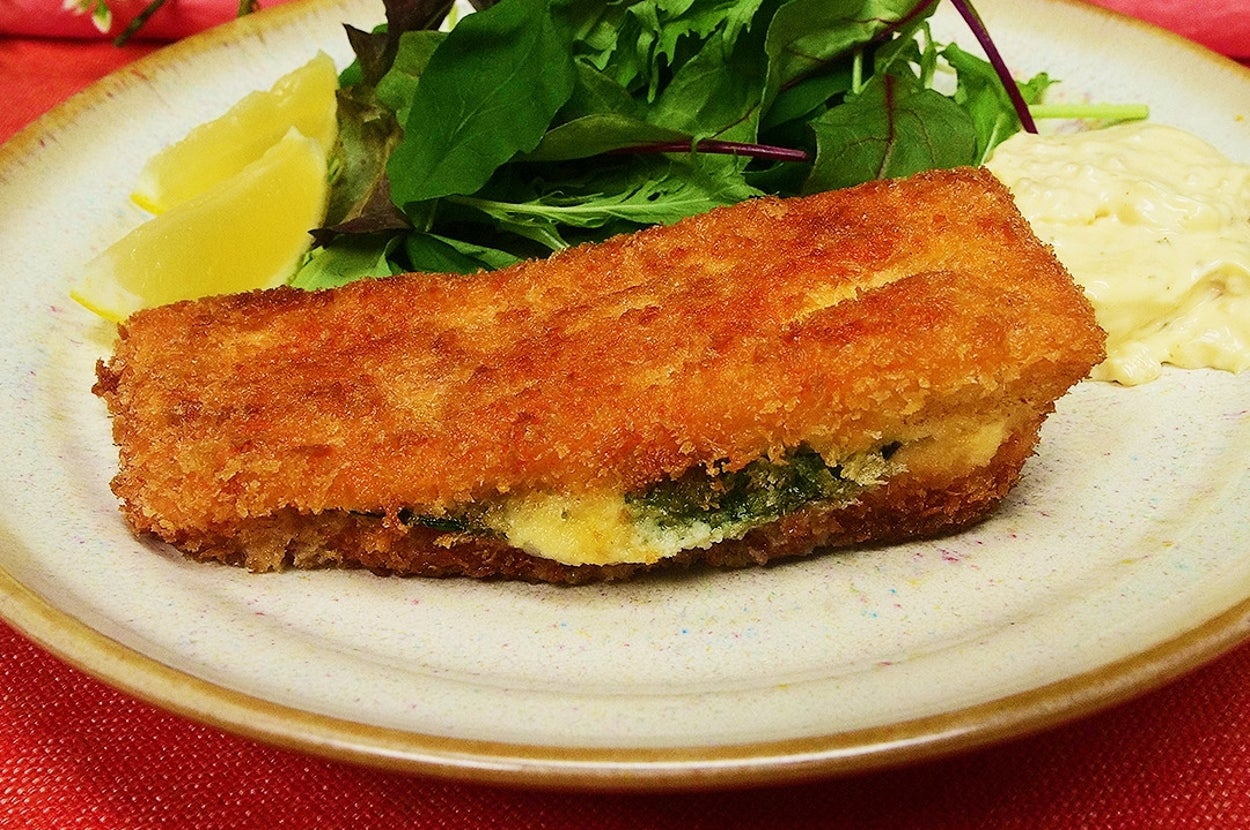 プレートに盛られたフライフィッシュ、レモンくし形切りとグリーンサラダを添えた料理。