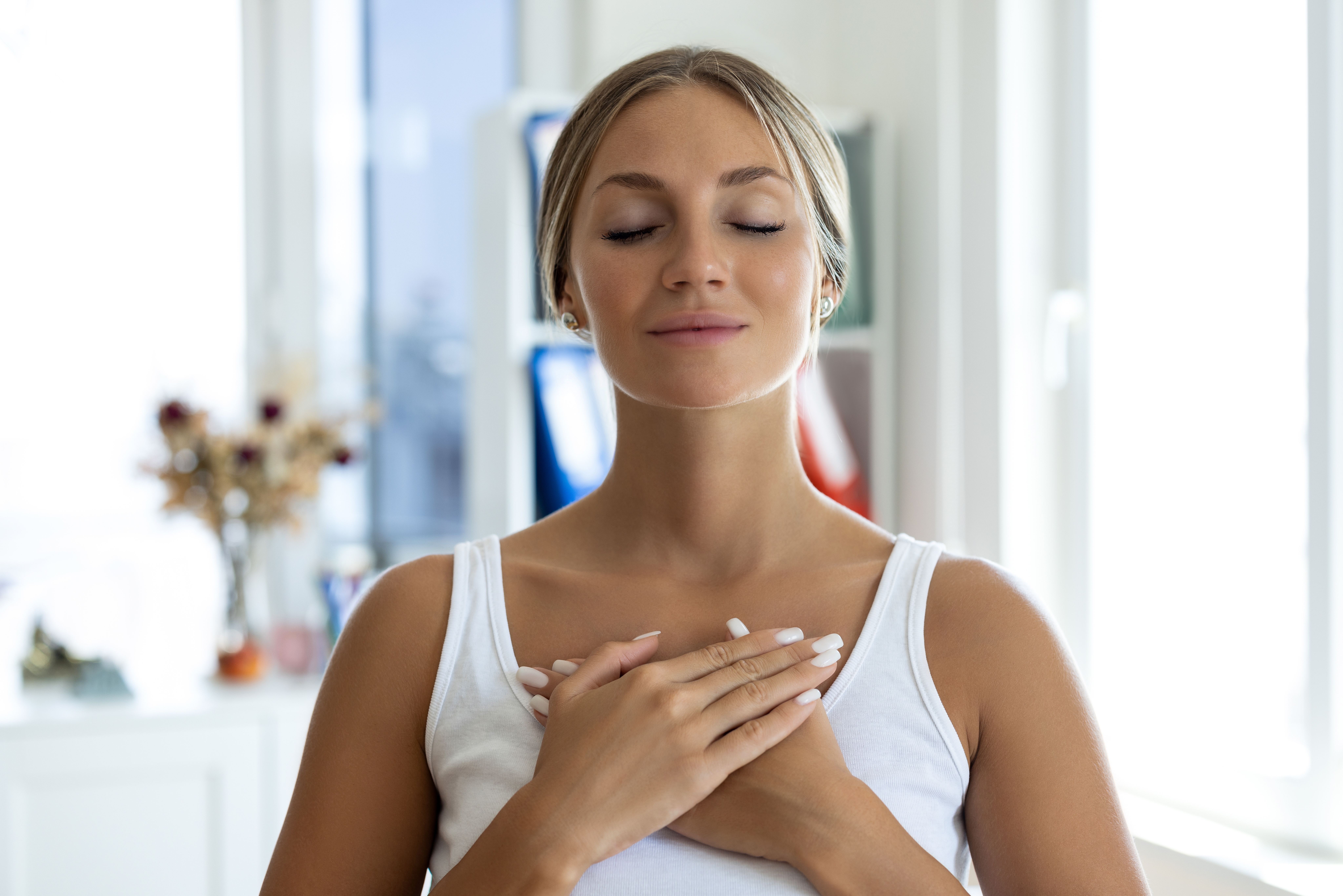 Person with closed eyes, hands connected  chest, lasting  successful  a peaceful indoor setting, suggesting meditation oregon  mindfulness practice