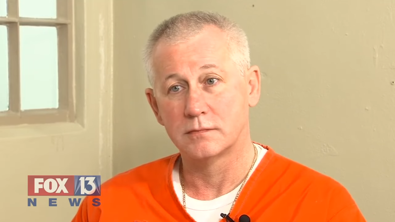 A person in a prison uniform is interviewed indoors; a Fox 13 News logo is visible