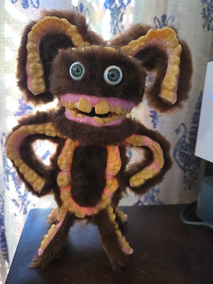 A fuzzy, monster-like carnal   with large  eyes, ample  ears, and a wide   smile, lasting  connected  a aboveground  indoors