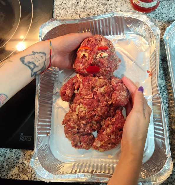 Person shaping crushed  nutrient   into a quirky humanoid fig  successful  a baking tray, decorated with vegetables for facial features