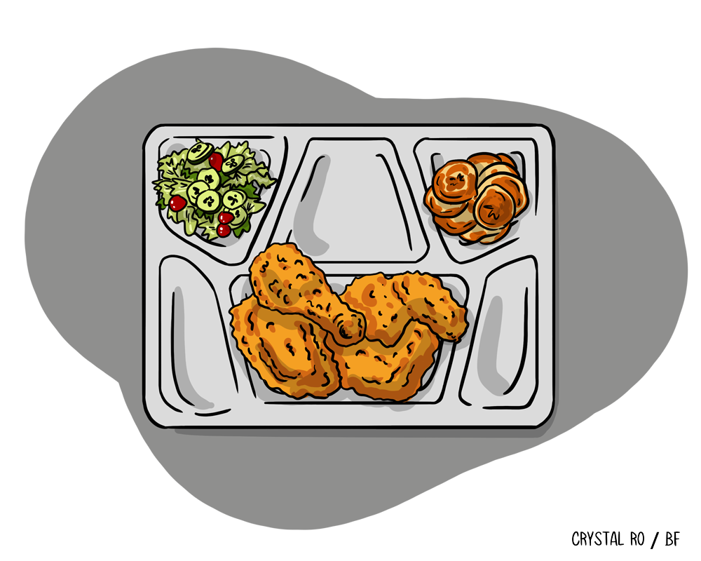 A cafeteria tray holds fried chicken pieces, a side salad with olives, and a portion of rolls