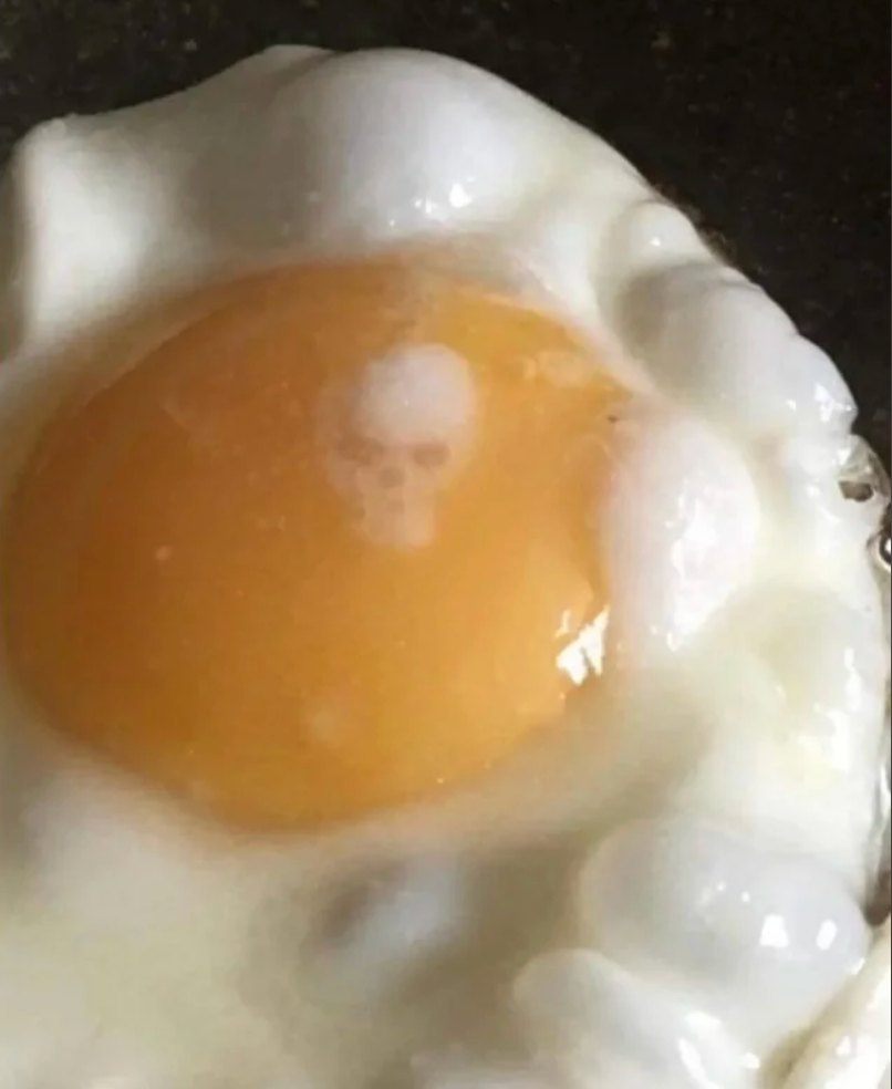 Fried ovum  with a yolk that resembles a skull face, featuring a chiseled  rima  and eyes pattern