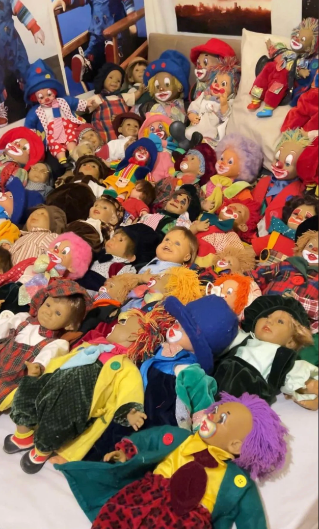 A ample  postulation  of clown dolls with varied expressions and outfits are sprawled crossed  a bed