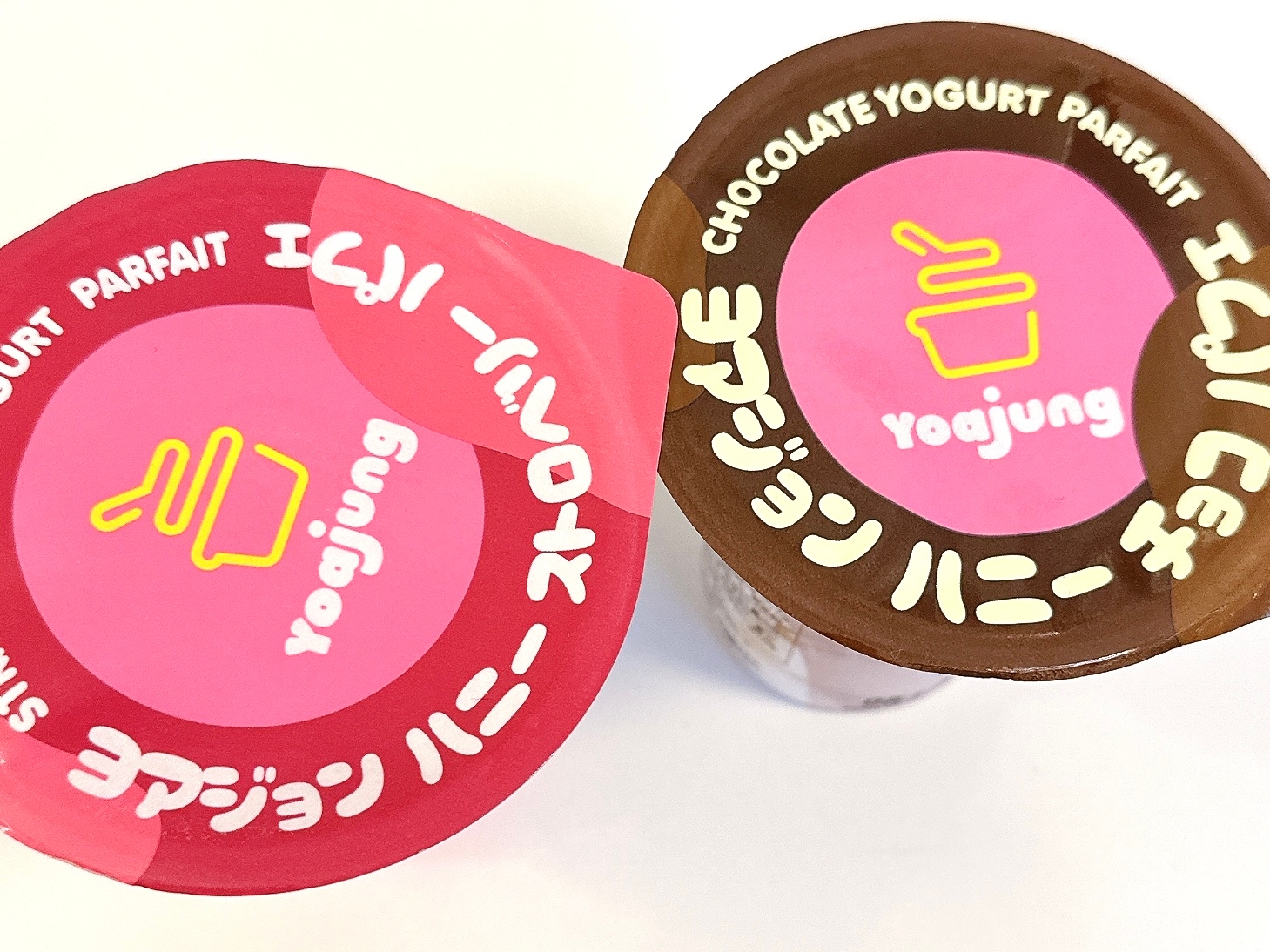 ヨーグルトパフェのカップ2つ、1つはストロベリー、もう1つはチョコレート。