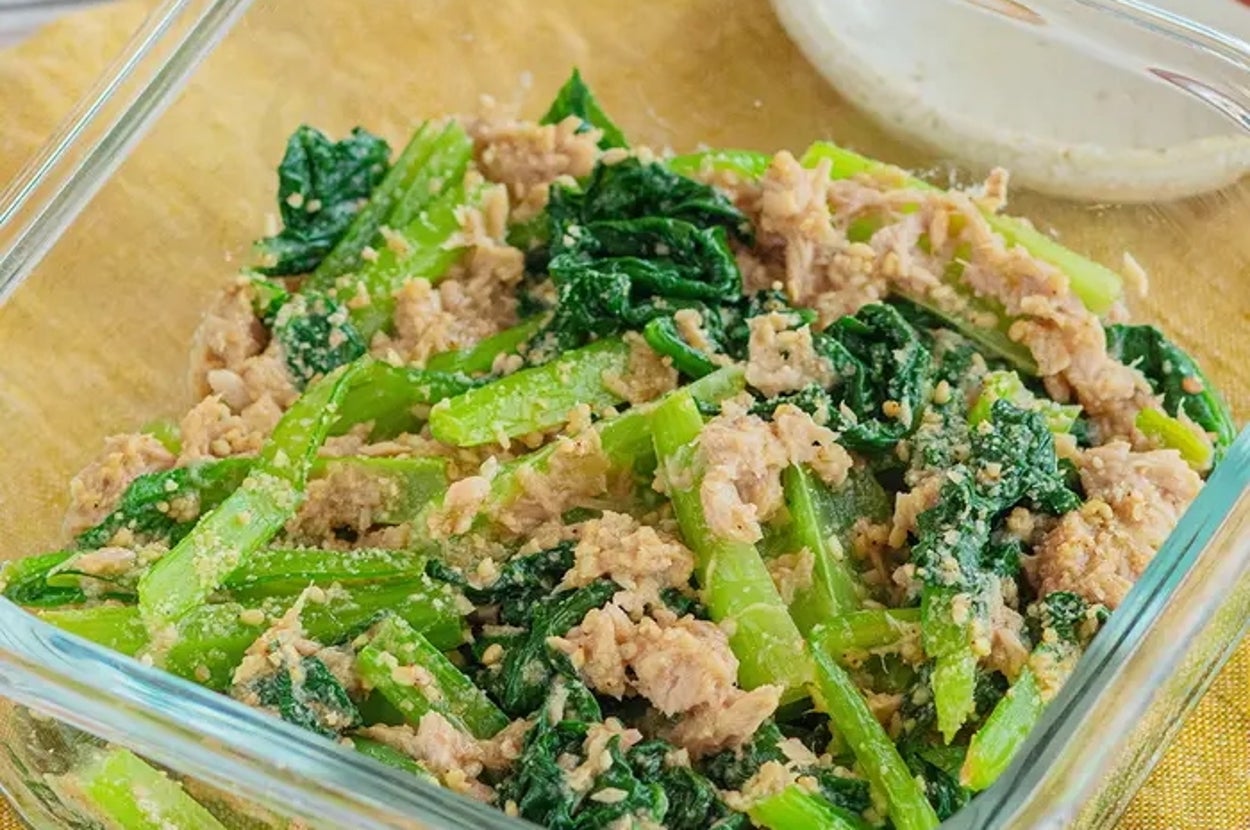 ガラス容器に入った小松菜とツナの和え物が置かれている。背景に箸と小皿がある。