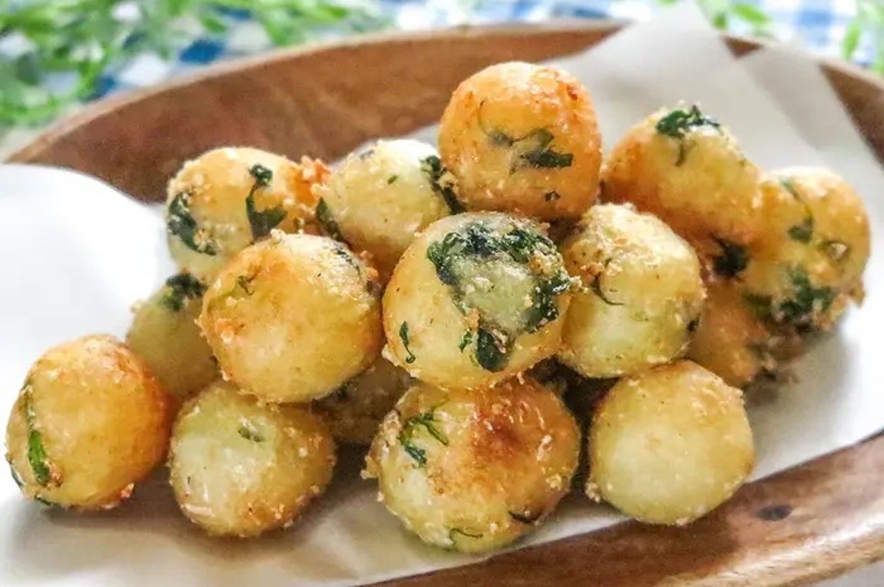 皿に盛られたきつね色のほうれん草入りコロコロフライドポテト。