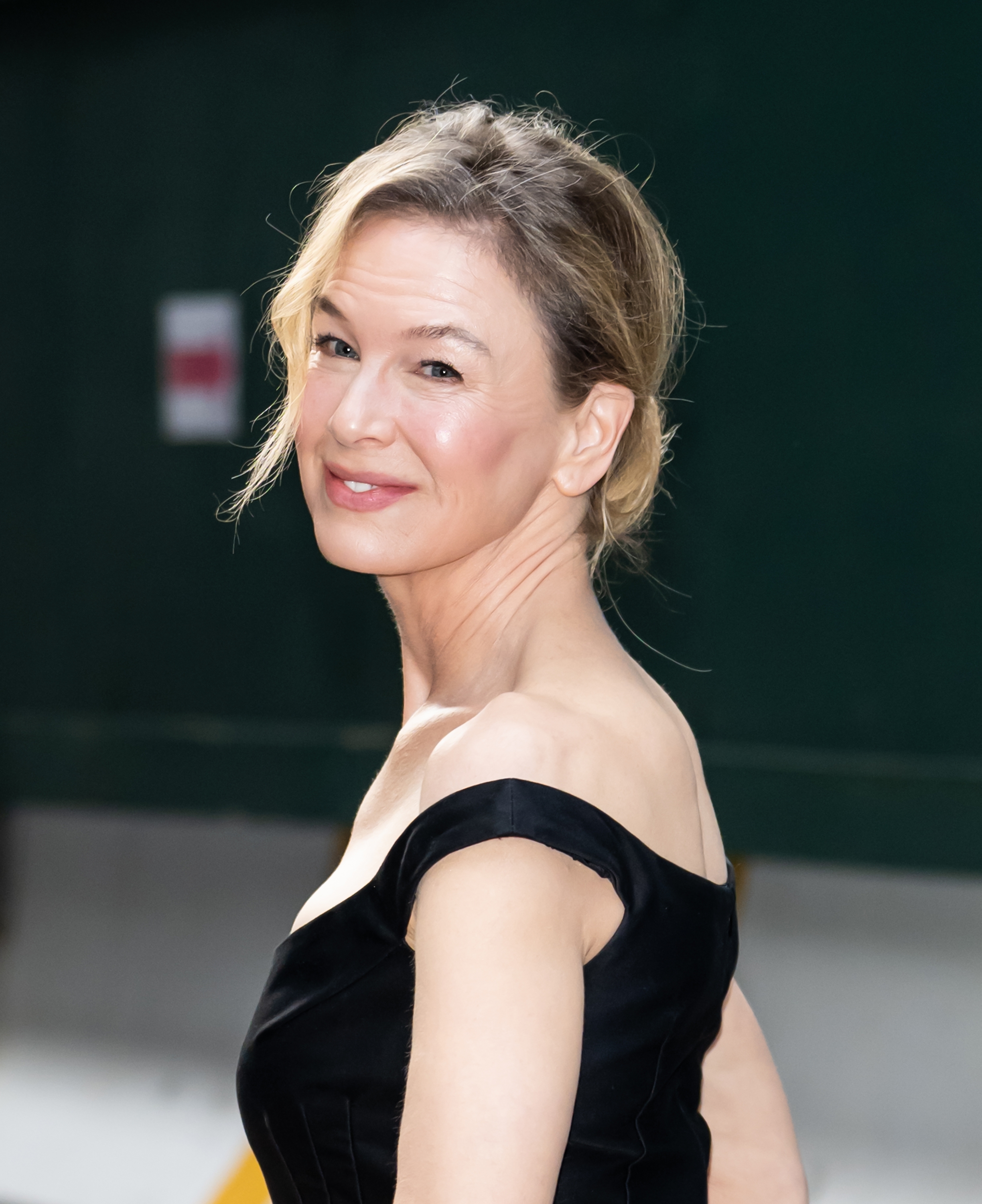 Person successful an elegant achromatic off-the-shoulder dress, smiling implicit their shoulder