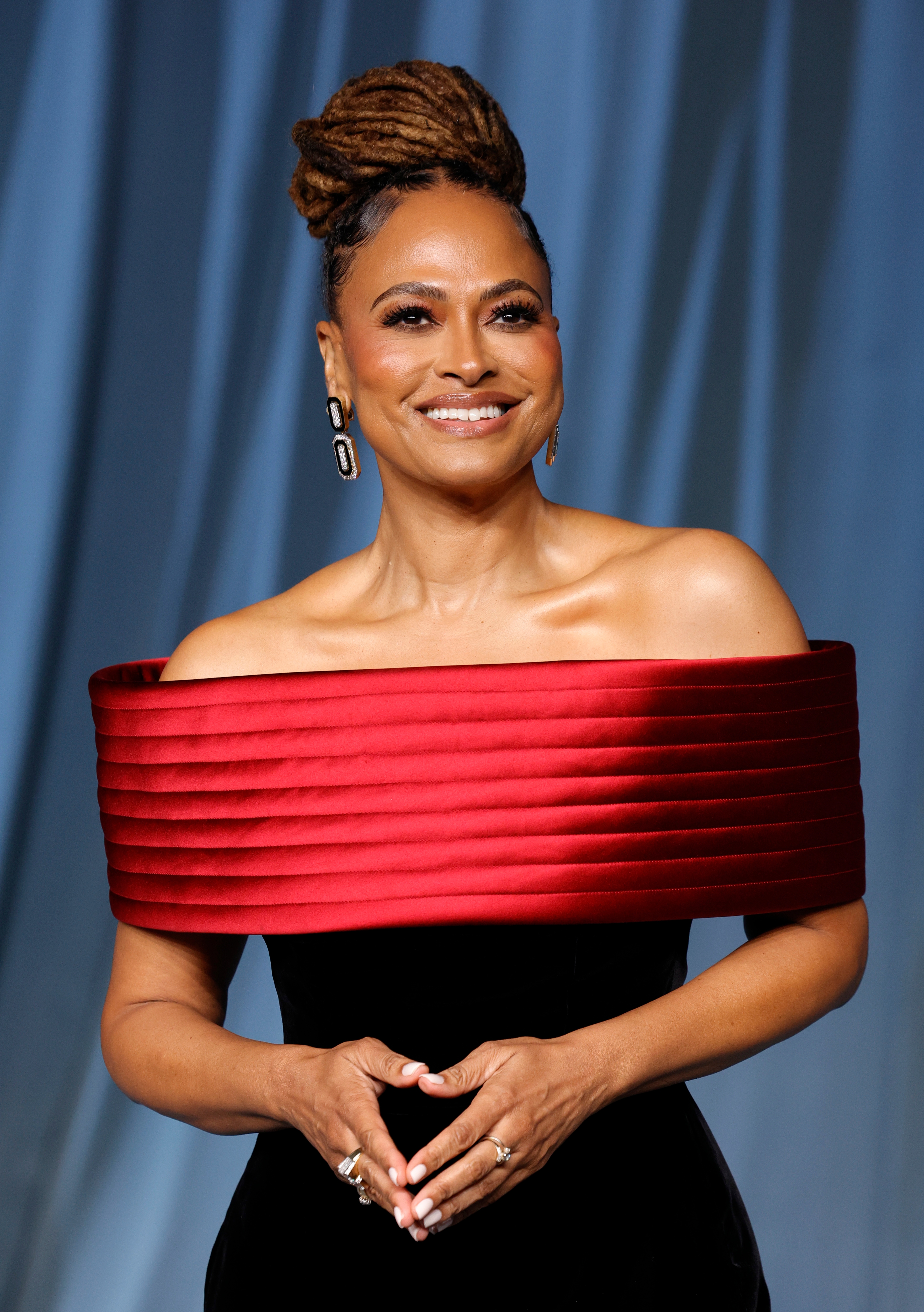 Celebrity successful an elegant, off-the-shoulder gown with a textured neckline posing connected the reddish carpet, smiling warmly