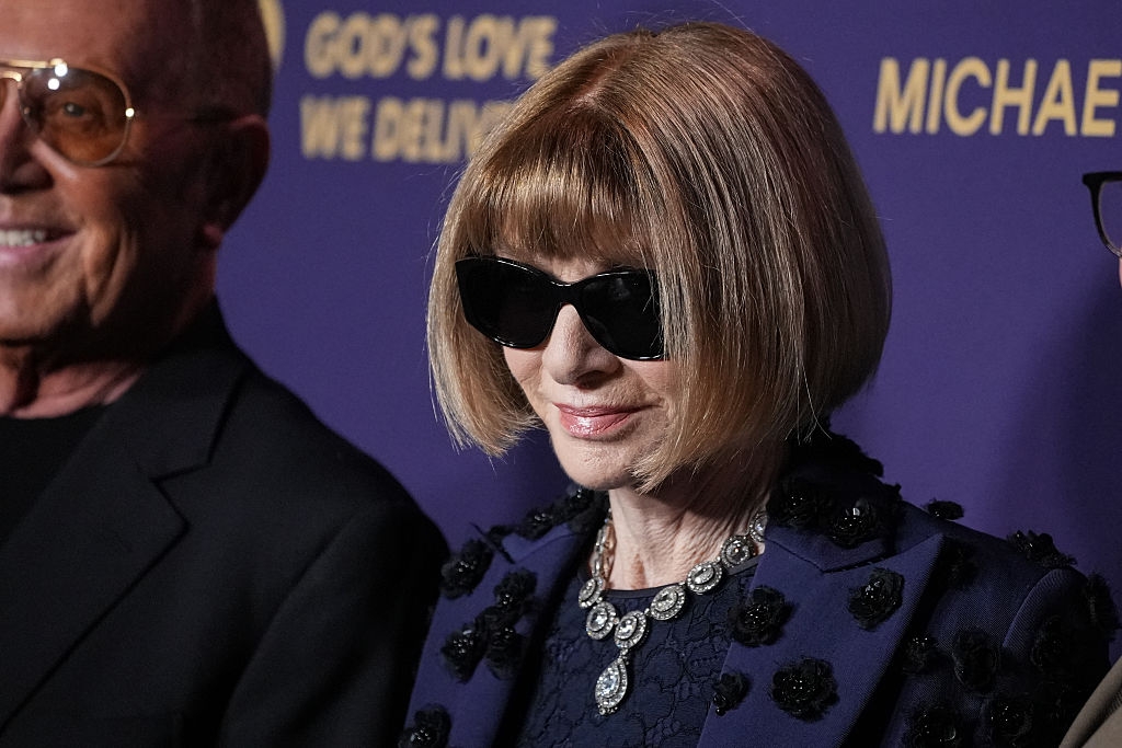 Person with bob haircut and sunglasses successful stylish attire astatine an event, wearing ornate jewelry