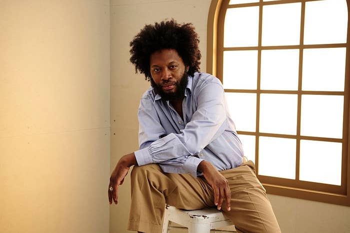 Person seated connected  a stool successful  a relaxed pose, wearing a airy  garment  and escaped   pants, successful  a country   with a ample  window