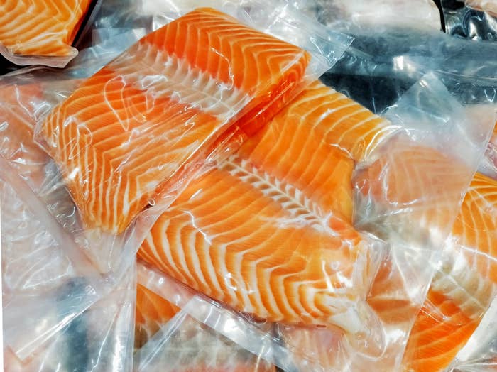 Vacuum-sealed salmon fillets are stacked, showcasing their fresh marbled texture, often used in recipes or meal prep
