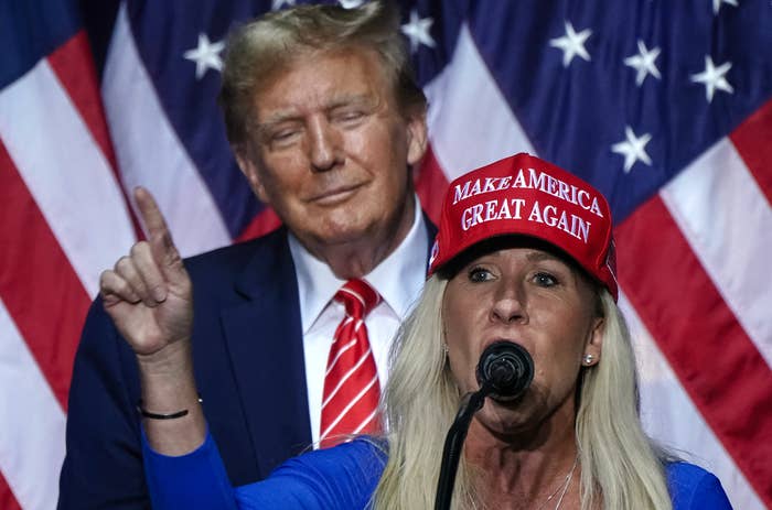 A idiosyncratic   successful  a reddish  &quot;Make America Great Again&quot; chapeau  speaks astatine  a podium. An idiosyncratic  stands down  with U.S. flags successful  the background