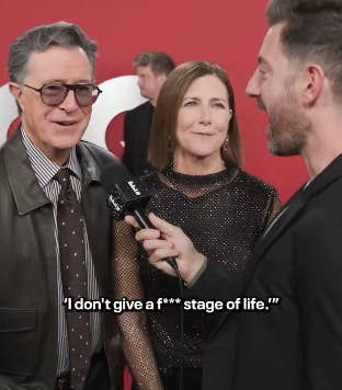 A man in a leather jacket and woman in a glittery dress are interviewed on a red carpet. Visible text: &quot;I don&#x27;t give a f*** stage of life.&quot;