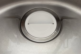 ステンレス製のシンク内の水切りバスケットがアップで撮影されています。