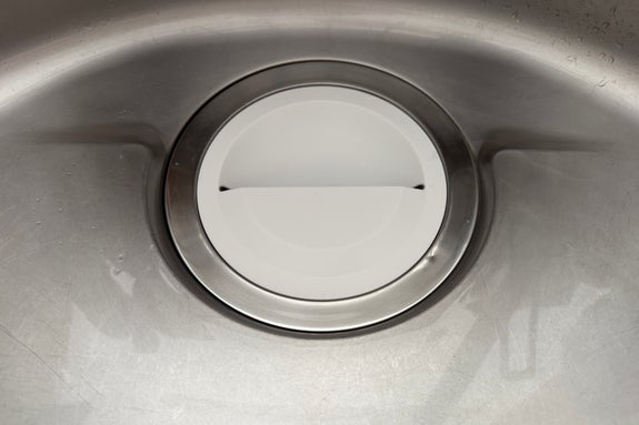 ステンレス製のシンク内の水切りバスケットがアップで撮影されています。