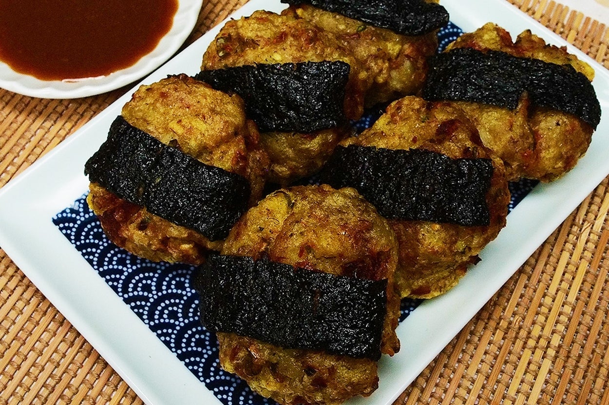 皿に海苔で巻かれた和風の揚げ物が並び、横にはたれが用意されています。おいしそうな和食のシーン。