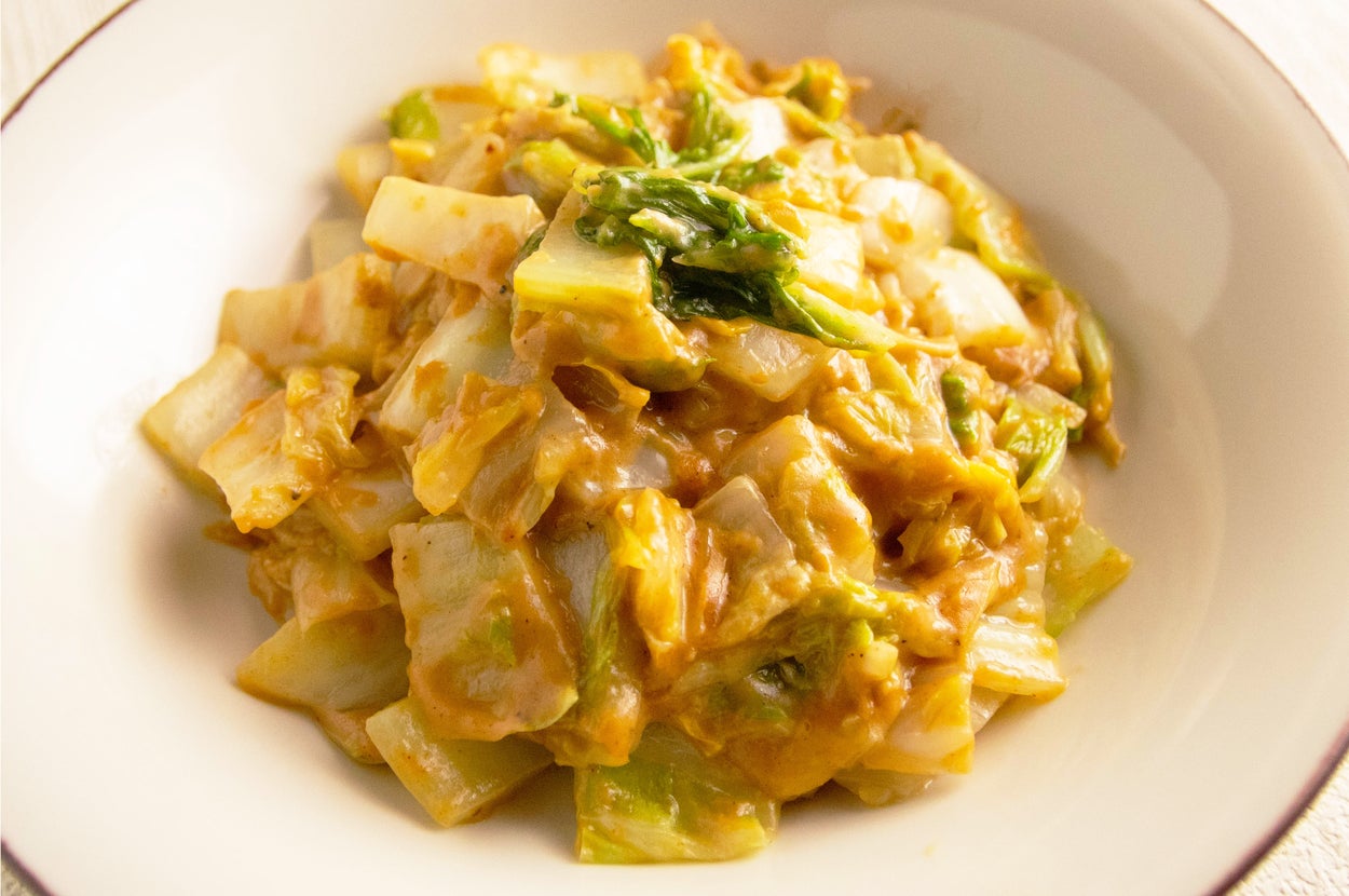 キャベツと緑の野菜が入った料理のボウル。クリーミーなソースで和えられている。