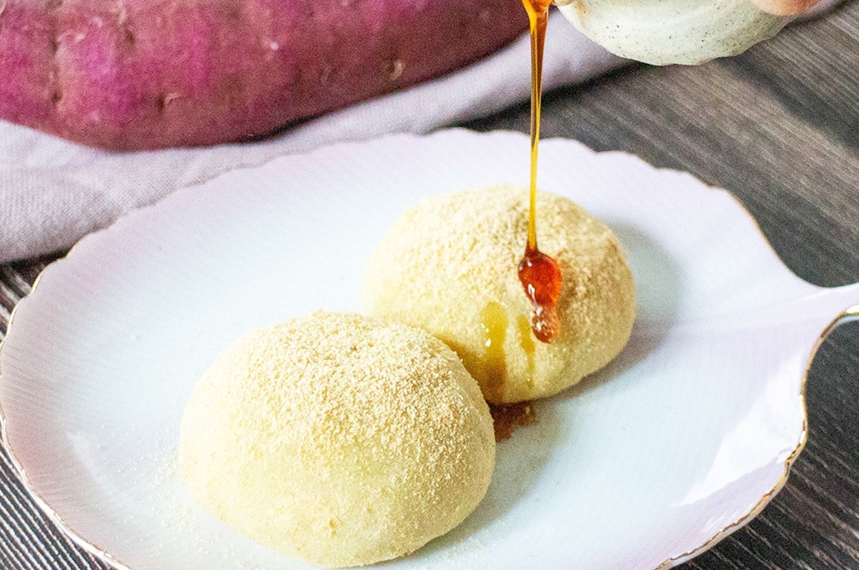 皿に盛られた2つの和菓子にシロップを注いでいる様子。背景にサツマイモ。