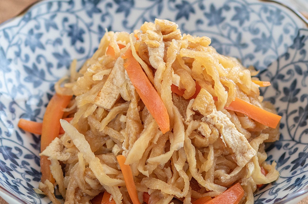 切り干し大根の煮物が器に盛られている。食材には千切りの大根とニンジンが含まれている。