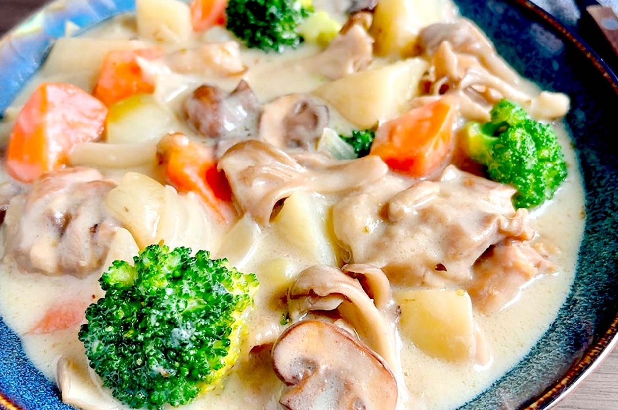 クリーミーな野菜シチュー、ブロッコリー、ニンジン、ジャガイモ、キノコが盛り込まれた食欲をそそる一皿。