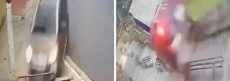 車が雨で濡れた坂道を下っている様子。道路は人けがなく静か。