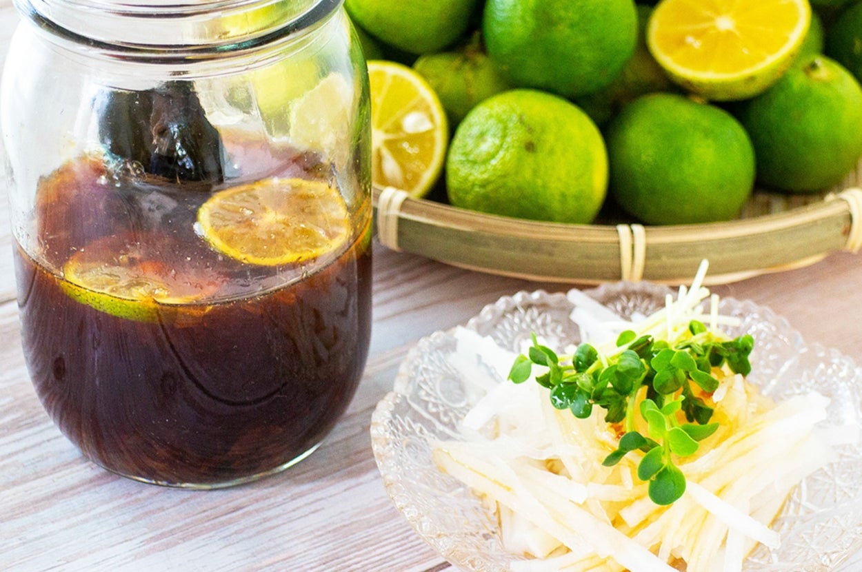 テーブル上にライム、レモンを浮かべたドリンクと大根サラダが置かれている。ナチュラルで爽やかな雰囲気。