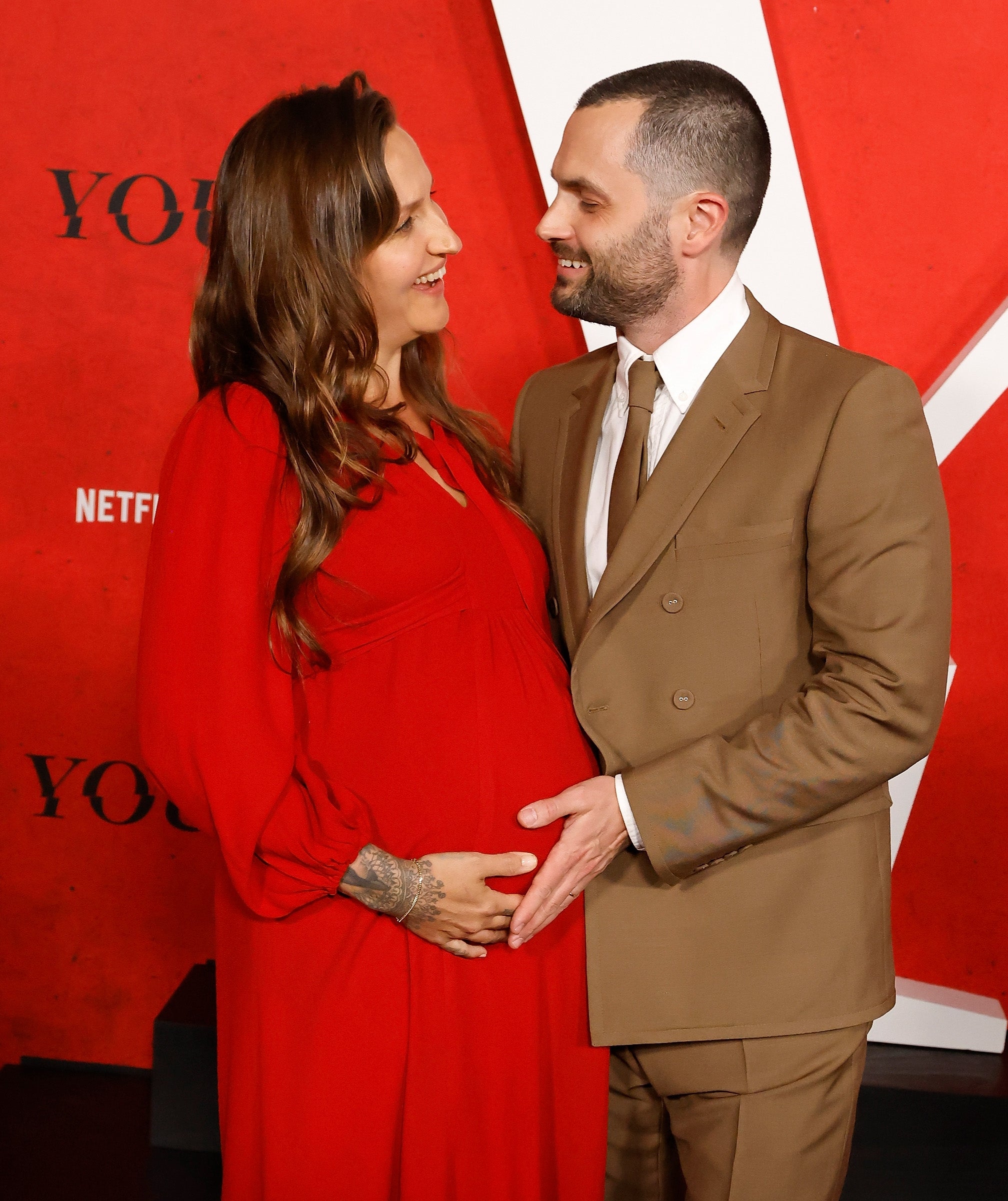 Domino and Penn smiling astatine each different connected a reddish carpet