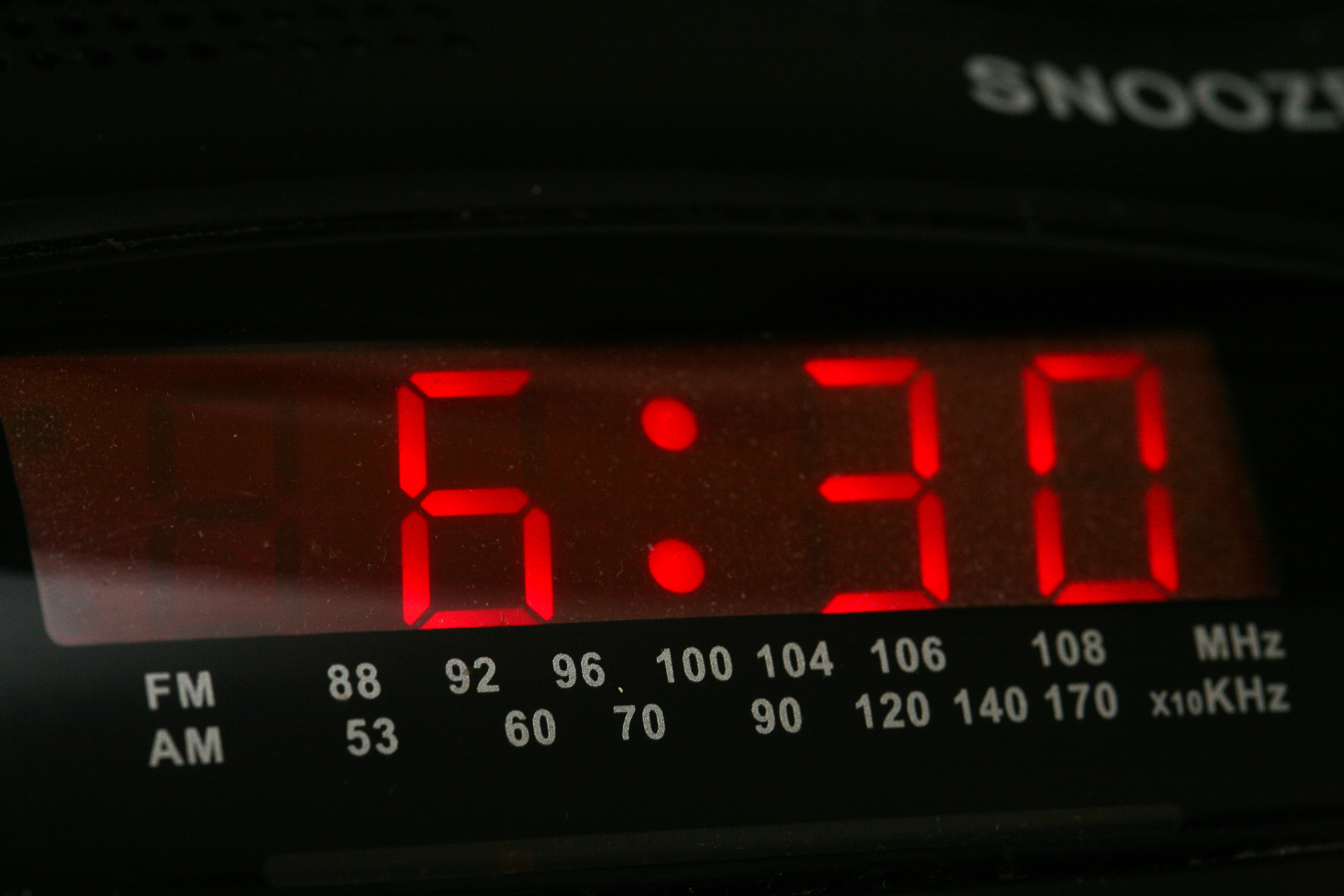 En digital vekkerklokke viser klokken 6:30 med radiofrekvensalternativer synlig nedenfor